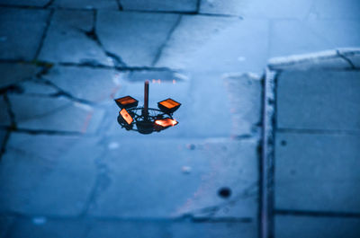 Reflection of illuminated floodlight on puddle during monsoon