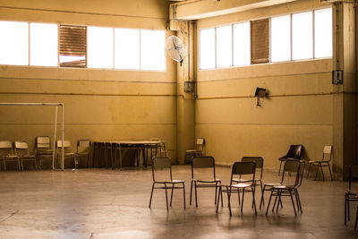 Empty chairs and table in building