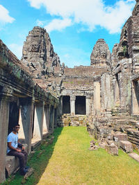 Low angle view of old temple against cloudy sky