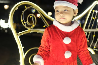 Portrait of cute girl dress santa suit at night