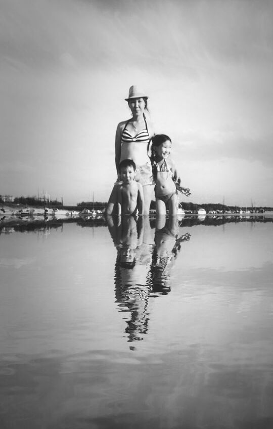 water, sky, waterfront, reflection, cloud - sky, river, lifestyles, pier, leisure activity, lake, built structure, full length, men, outdoors, connection, nature, standing, day