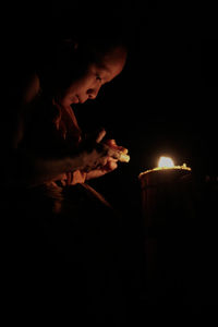 Midsection of illuminated man in darkroom