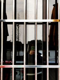 Reflection of person on glass window of building