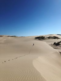 Scenic view of desert against clear blue sky