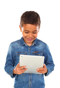 Boy holding mobile phone while standing against white background