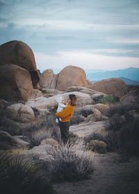 A woman with a baby is standing in a desert of california