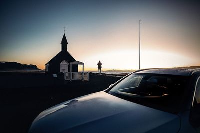 Silhouette car on road against sky during sunset