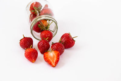 High angle view of strawberries in jar against white background