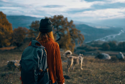 Rear view of woman with dog on field