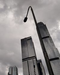 Low angle view of modern buildings against cloudy sky