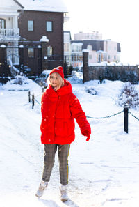 Young stylish blonde woman on the street has fun, posing in snowy, frosty