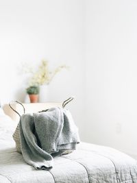 Close-up of sweater in purse on bed at home