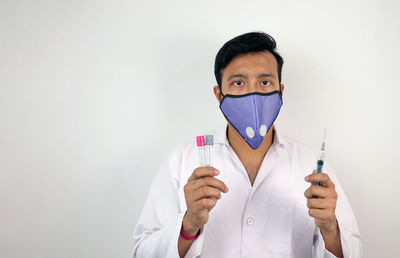 Portrait of man standing against white background