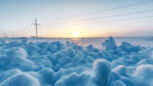 Scenic view of frozen lake against sky during sunset