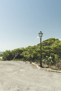 Street light by road against clear sky