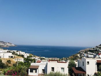 High angle view of townscape by sea against clear sky