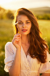 Portrait of young woman sitting on car