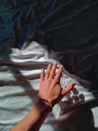 High angle view of woman hand on bed