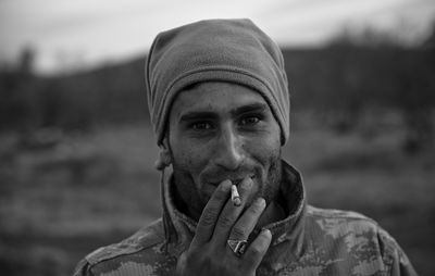 Close-up portrait of young man smoking outdoors