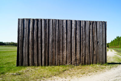Wooden fence on field against sky