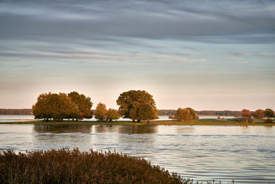 Scenic view of lake against sky at sunset