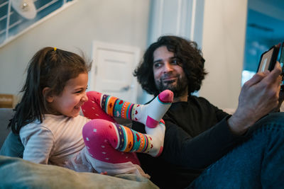 Man and woman using mobile phone at home