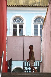 Rear view of man standing against building