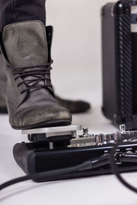 Low section of man on pressing guitar effects pedal