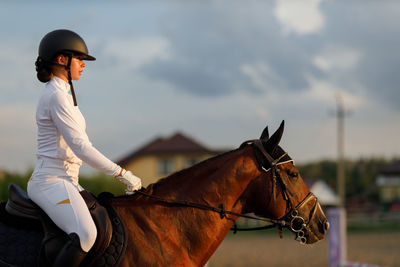 Side view of man riding horse on field