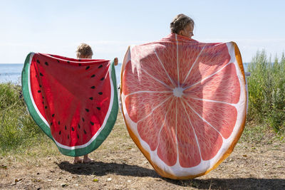 Kids holding beach towels with fruit pattern