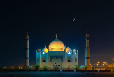 Illuminated building against sky at night