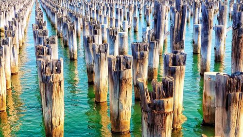 Full frame shot of wooden posts in sea