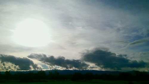 Scenic view of field against cloudy sky