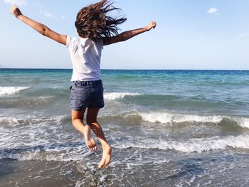 Full length of woman enjoying at beach against sky