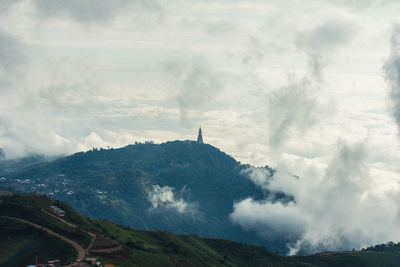 Stupa on mountain against cloudscape