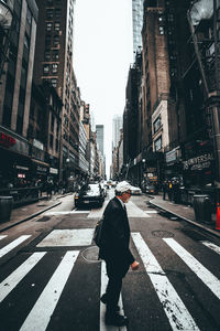 Rear view of man walking on city street