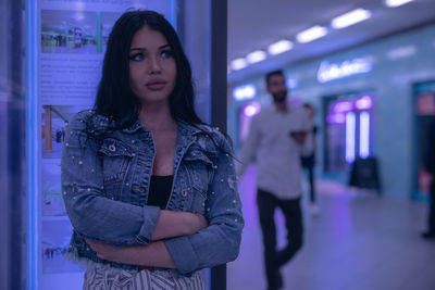 Fashionable young woman standing in illuminated built structure