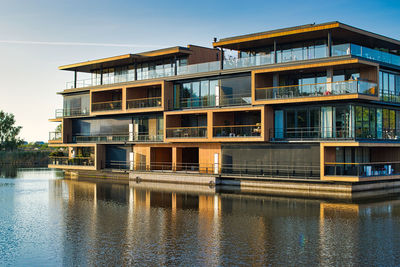 Building by river against sky in city