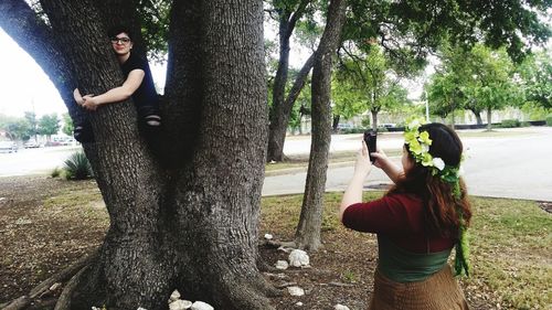 Woman standing on tree trunk