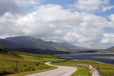 Road leading towards mountains against sky