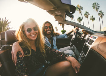 Portrait of smiling young woman sitting in car