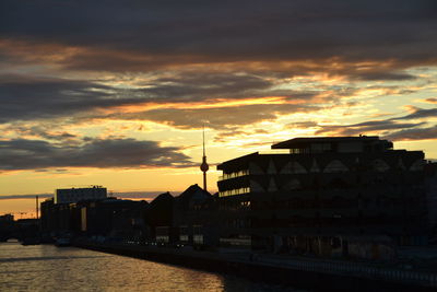 Buildings against cloudy sky at sunset