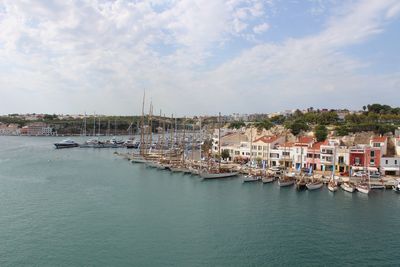 Sailboats in sea against sky in city