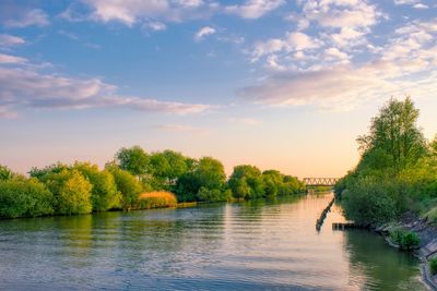 Scenic view of river against sky at sunset