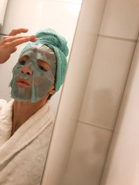 Low angle view of woman with reflection on mirror