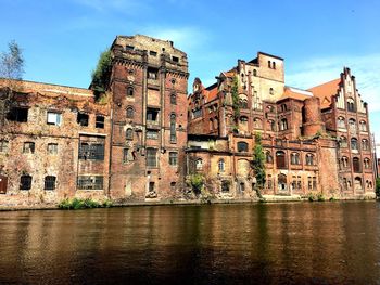 Old building by river with city in background