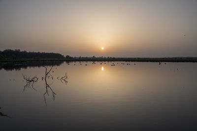 Scenic view of lake against sky during sunset