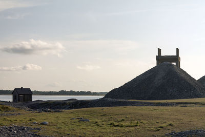 Built structure by water against sky