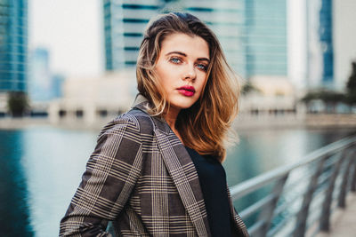 Portrait of beautiful young woman standing in city