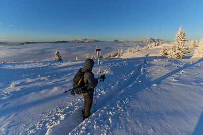 Man on snow covered field against sky